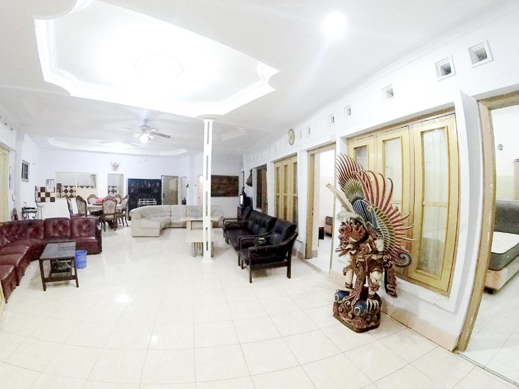 uma grande sala de estar com sofás e um sofá em With Friends Homestay Jogja em Yogyakarta