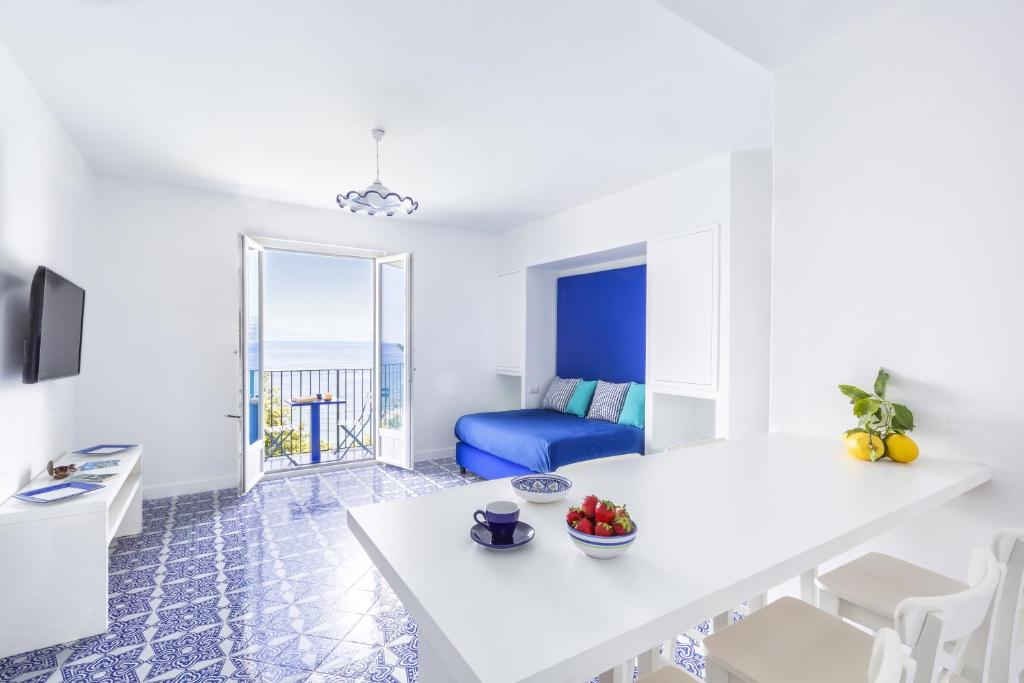 un soggiorno con tavolo bianco e sedia blu di Blue View Capri Apartment a Capri