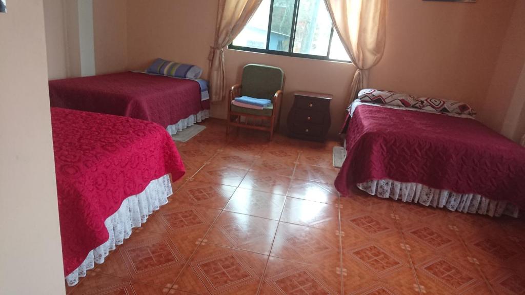 Cette chambre comprend 2 lits et une fenêtre. dans l'établissement Casa de Celeste, à Puerto Baquerizo Moreno
