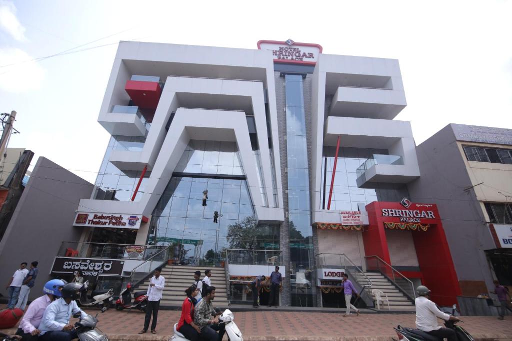 a building with people sitting in front of it at HOTEL SHRINGAR PALACE in Hubli