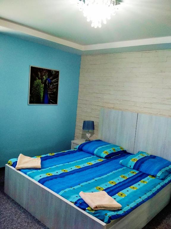 贝乌哈图夫Noclegi i Restauracja Gracja的卧室设有一张大床,拥有蓝色的墙壁