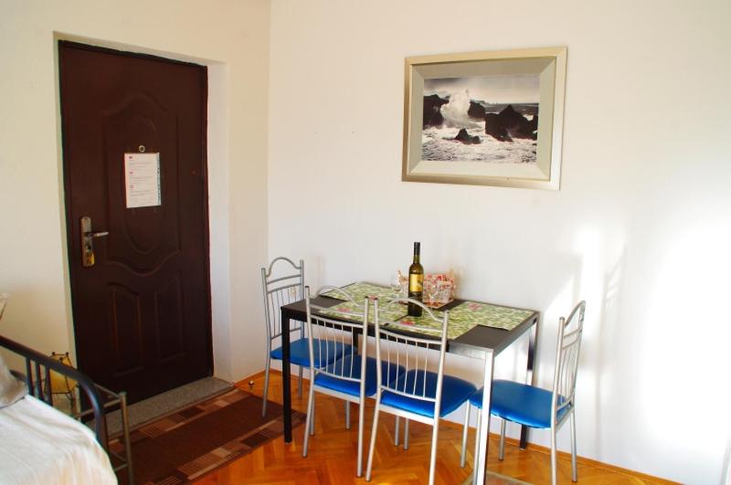 uma sala de jantar com uma mesa e cadeiras e uma porta em Apartment Matea em Matulji