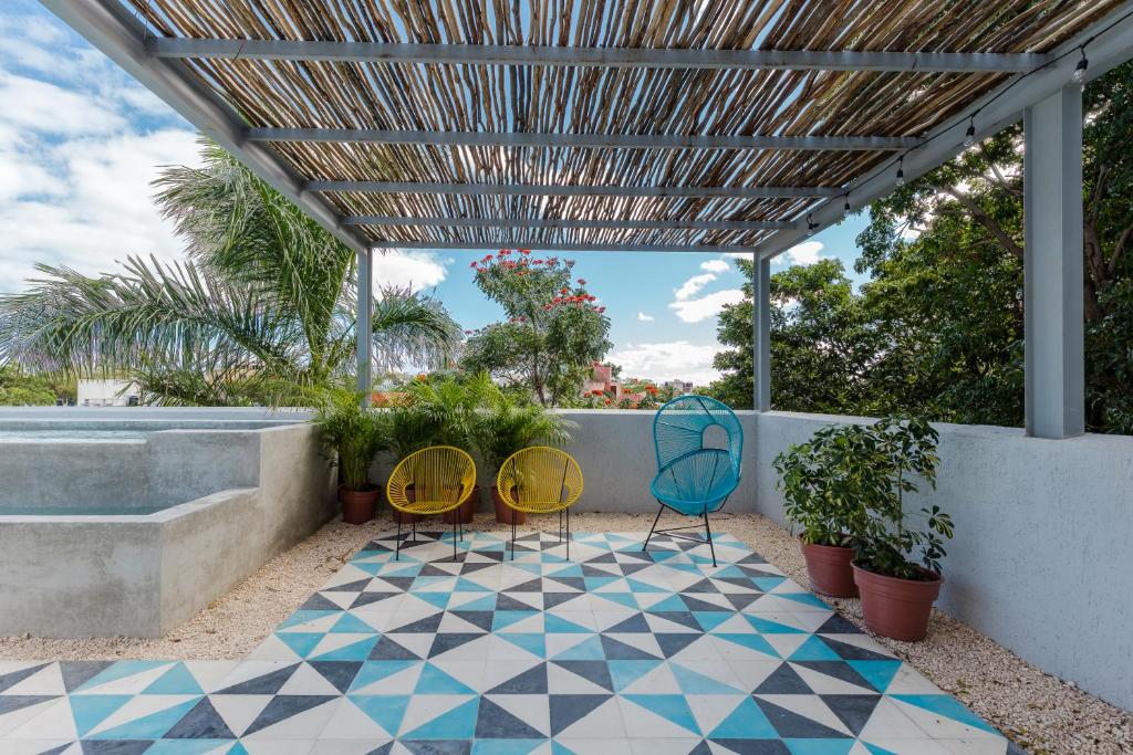 eine Terrasse mit 3 Stühlen und einem Pool in der Unterkunft Studios Downtown Cancun in Cancún
