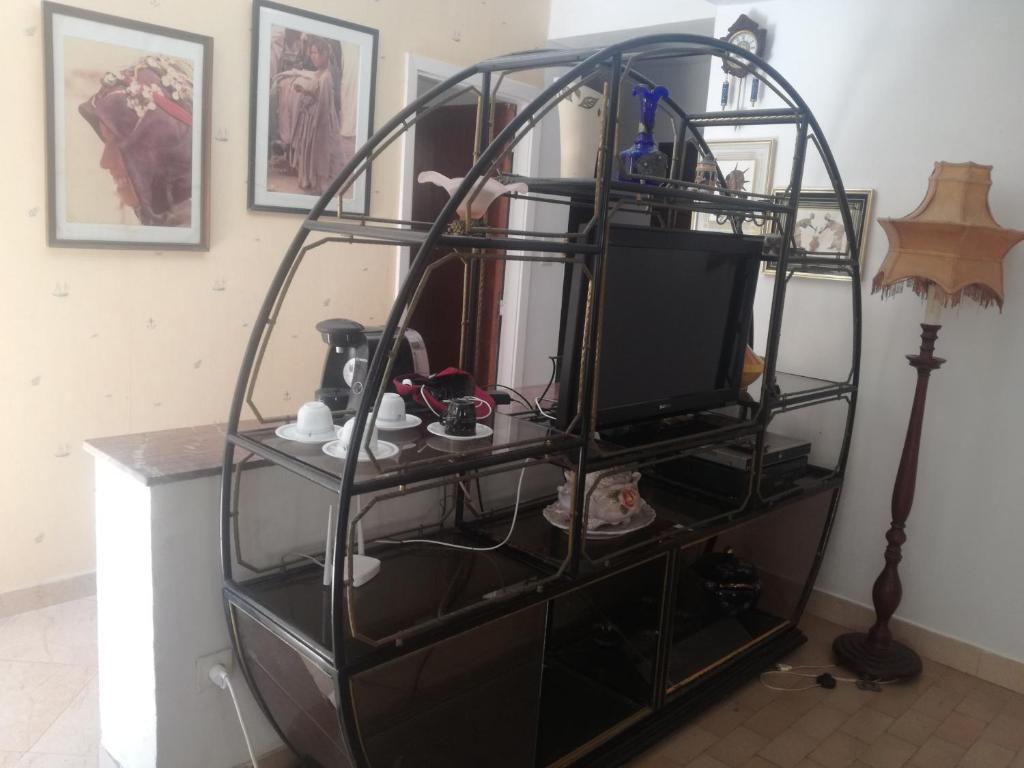 a room with a shelf with a television and a lamp at Miramar in El Harhoura