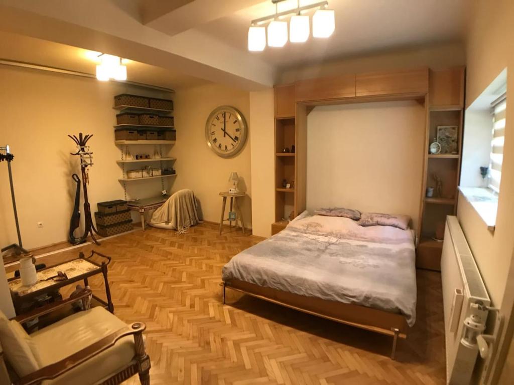 a bedroom with a bed and a clock on the wall at Apartment Vintige in Cluj-Napoca