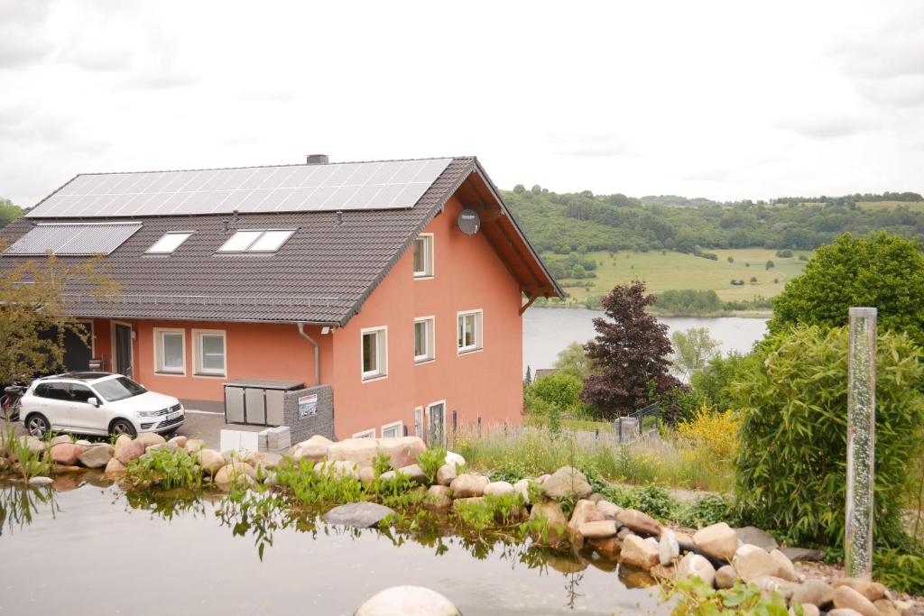 ein Haus mit einem Solardach und einem Auto vor dem Haus in der Unterkunft Eifelglück in Schalkenmehren