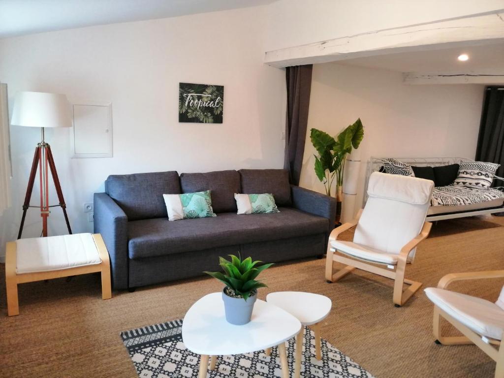ein Wohnzimmer mit einem Sofa und einem Tisch in der Unterkunft LOFT COSY - CENTRE HISTORIQUE climatisé in Revel