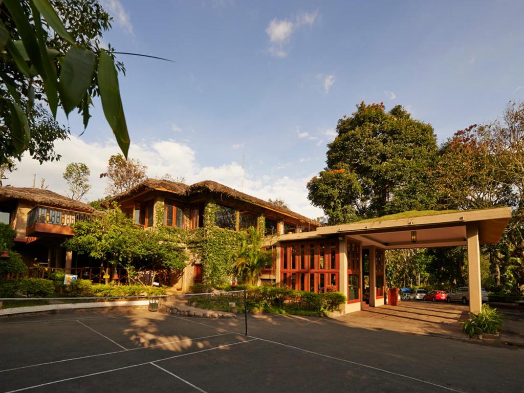 ein Gebäude mit einem Parkplatz davor in der Unterkunft Club Mahindra Thekkady in Thekkady