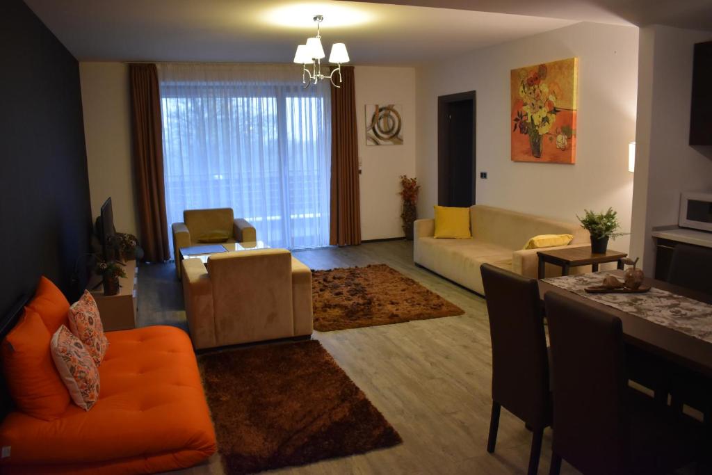 uma sala de estar com um sofá laranja e uma mesa em Silver Mountain G1 15 em Poiana Brasov