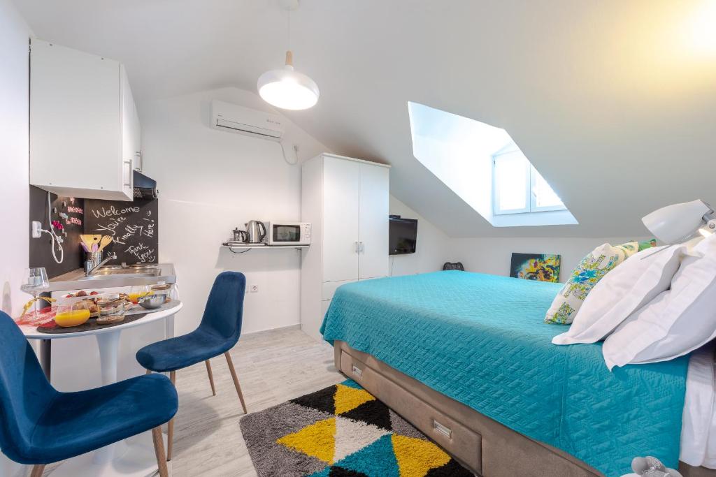 1 dormitorio con 1 cama, mesa y sillas en Apartments Grgich, en Dubrovnik