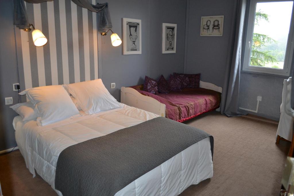 um quarto com uma cama e um sofá em Logis le Relais Sarrasin em Vézénobres