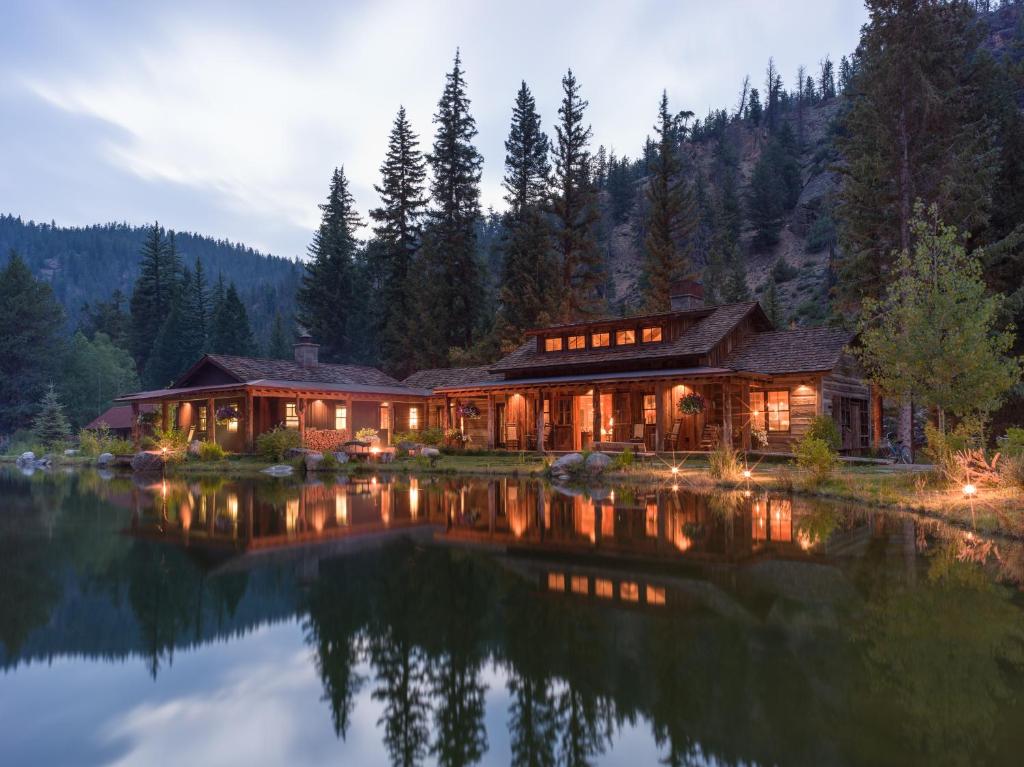 a house on a lake at night at Eleven Taylor River Lodge in Almont