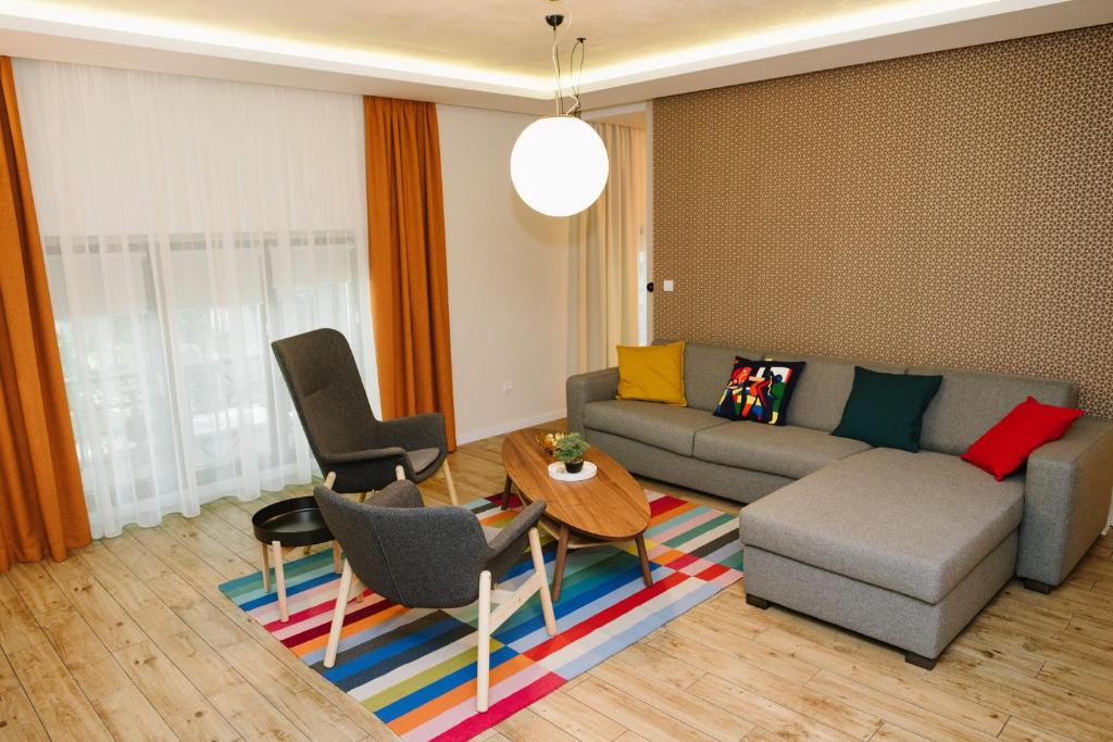 a living room with a couch and a table and chairs at Apartman Donner Centar II in Subotica