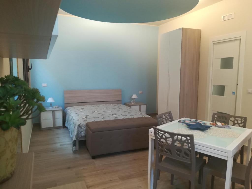 1 dormitorio con 1 cama, mesa y sillas en Casa Mirtillo, en Bernalda