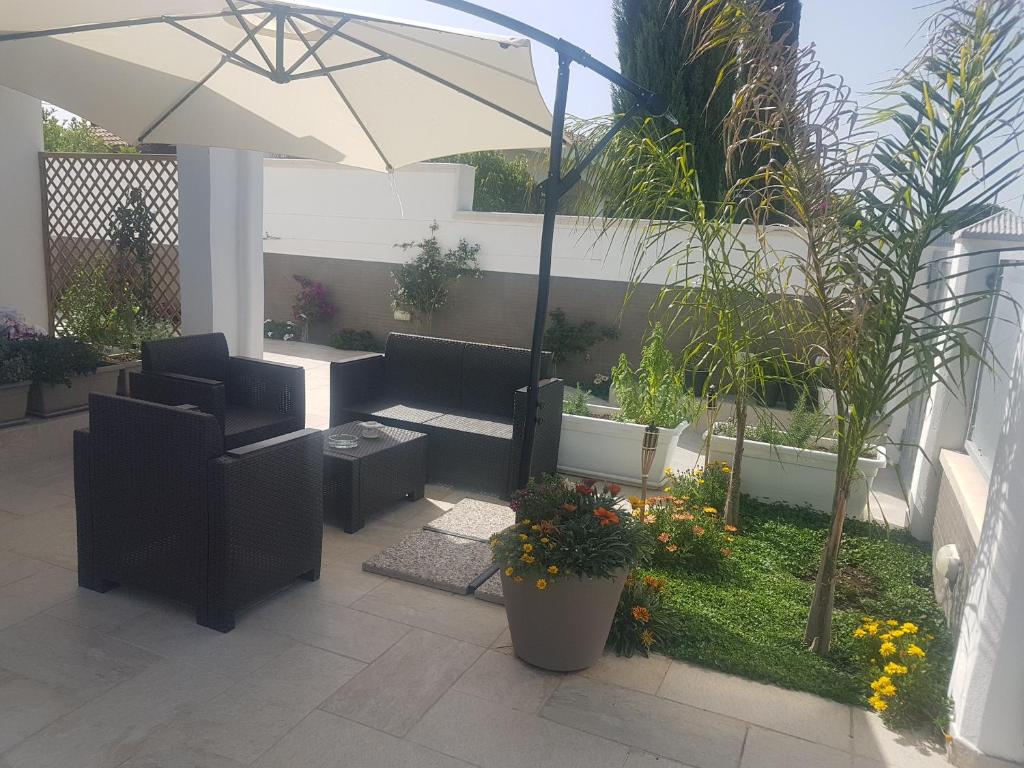 a patio with two couches and an umbrella at B&B villa brezza marina in Sant'Isidoro