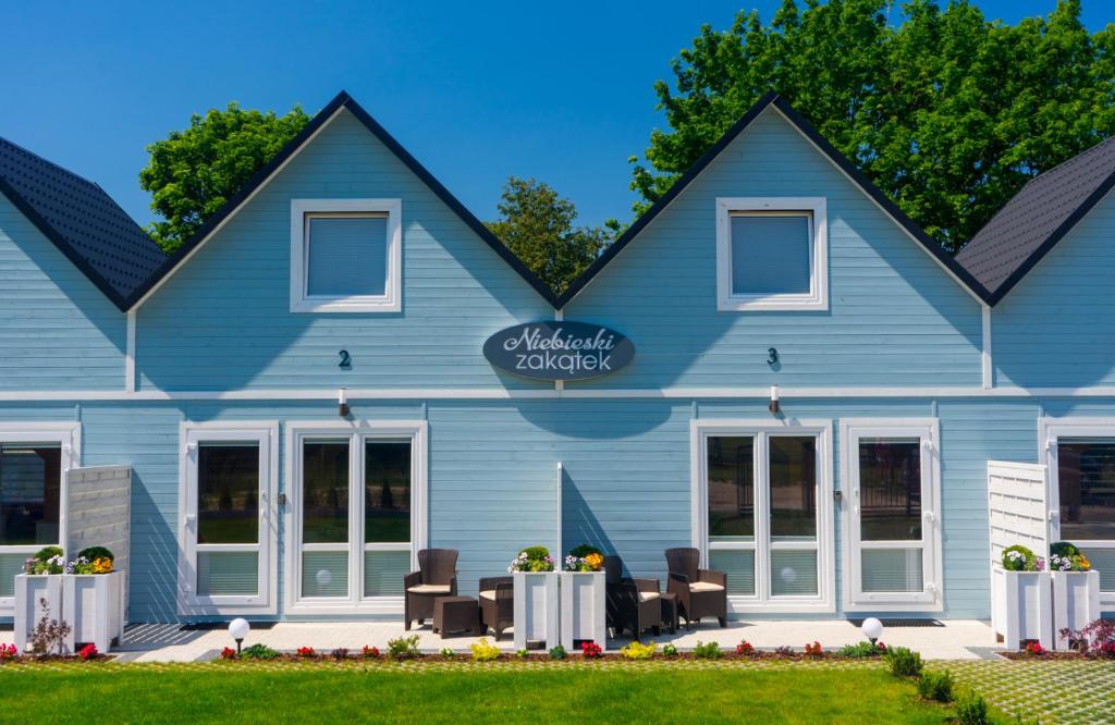 a blue building with chairs in front of it at Niebieski Zakątek in Wisełka