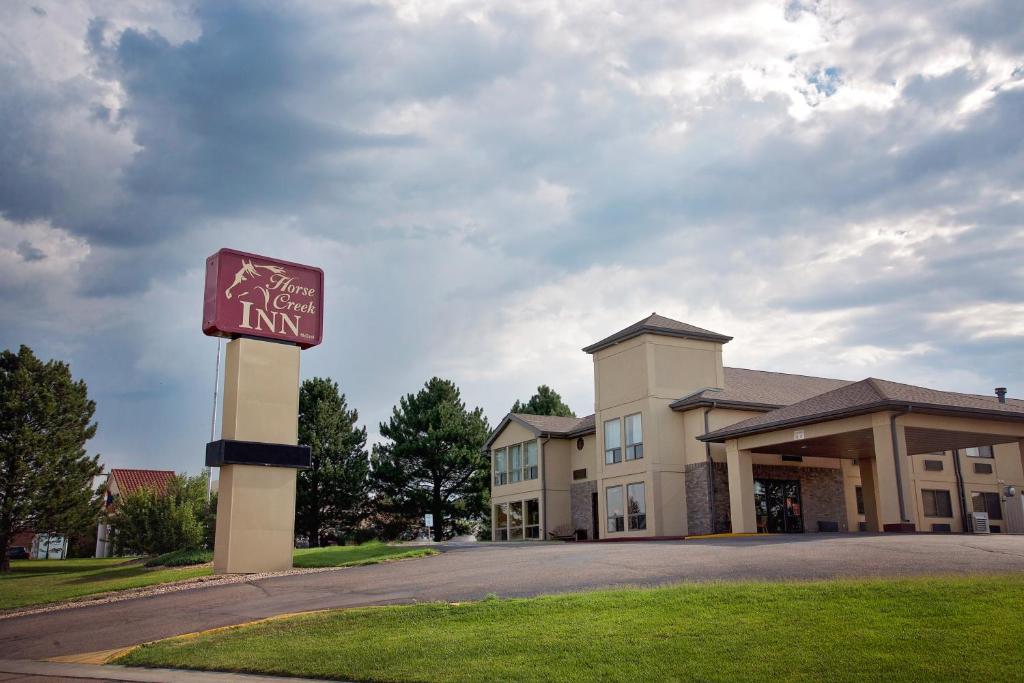 um sinal para uma estalagem em frente a um edifício em Horse Creek Inn em McCook