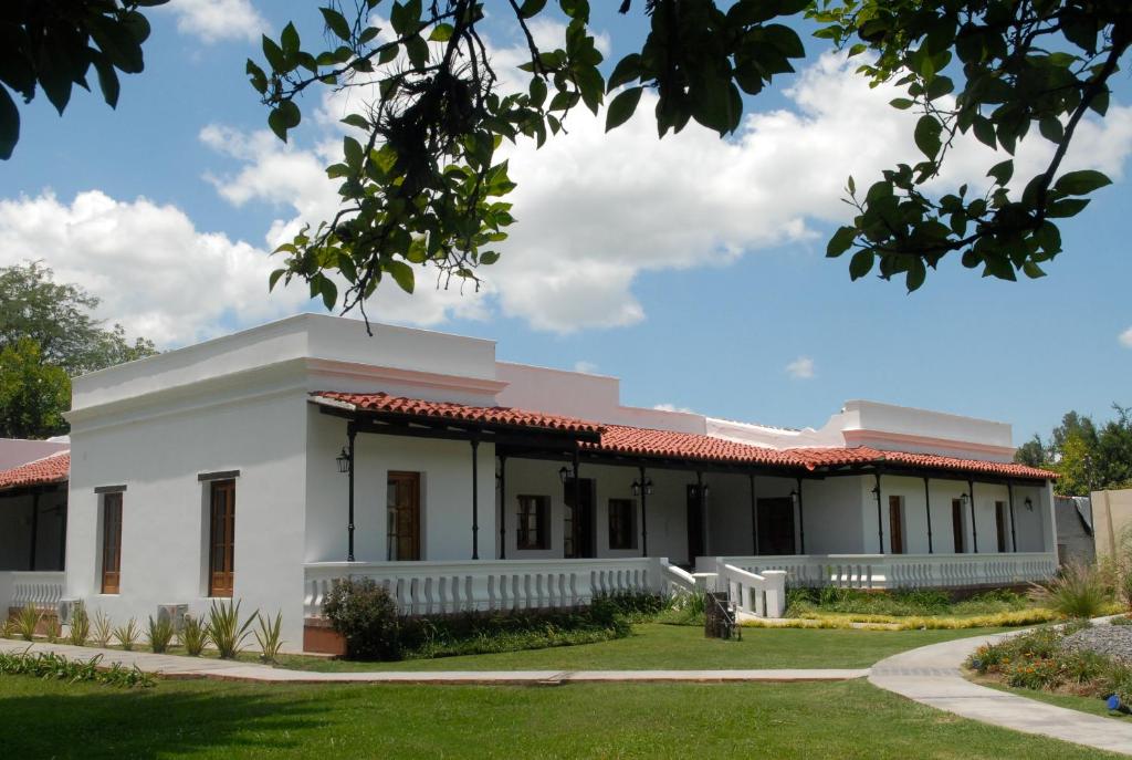 a white building with a red roof at Hotel Cerros in Rosario de Lerma
