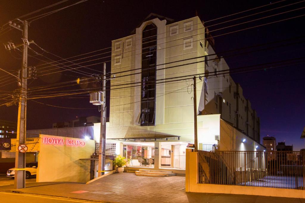 un bâtiment blanc avec un panneau sur son côté dans l'établissement Hotel Igapó, à Londrina