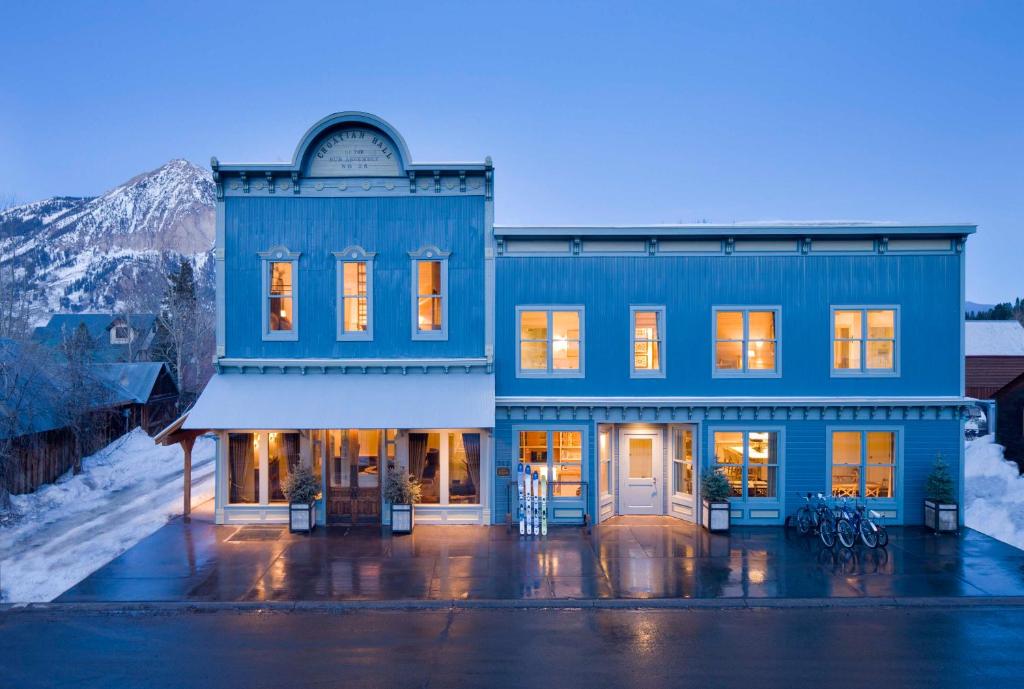 a blue building with lights on in the snow at Eleven Scarp Ridge Lodge in Crested Butte