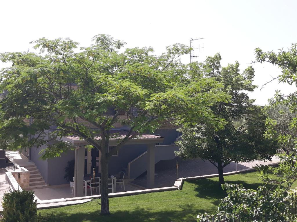 Blick auf ein Haus mit Bäumen im Hof in der Unterkunft Cuoreverde Matera in Matera