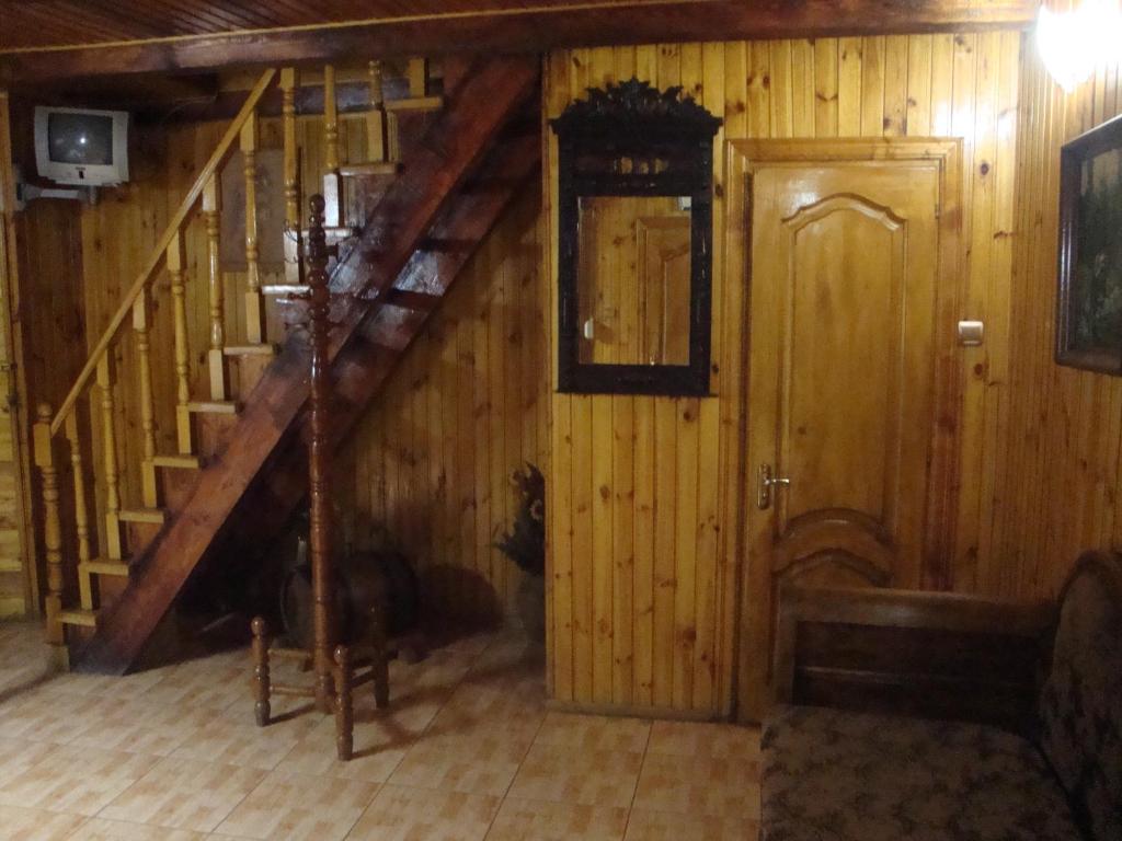 um quarto de madeira com uma escada e uma porta em Domik s saunoy na Ogiyenko em Kamianets-Podilskyi