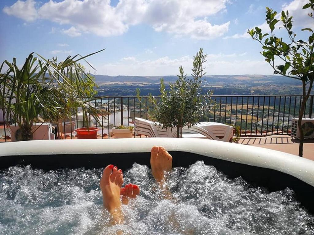 una persona acostada en una bañera de hidromasaje con sus pies en el agua en CASA RICARDO " LE GITE ", en Arcos de la Frontera