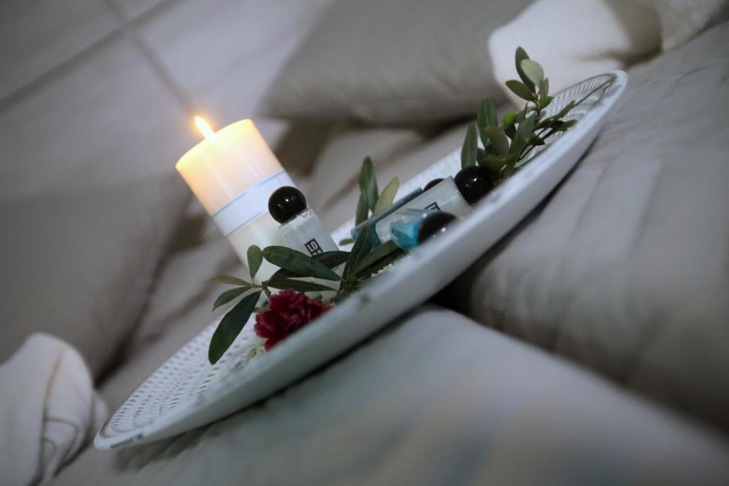 a remote control with a candle and flowers on it at Pier Beach Hotel Apartments in Limassol