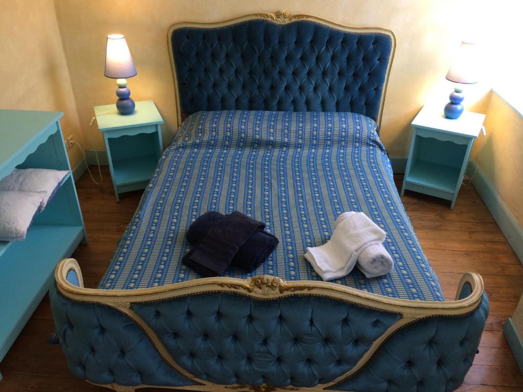 a blue bed in a room with two night stands at Gites de Mirepoix "le Presbytère" in Mirepoix