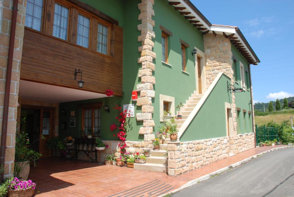 zielony budynek ze schodami i kwiatami w obiekcie Apartamentos Rurales Casa Tata w mieście Villaviciosa