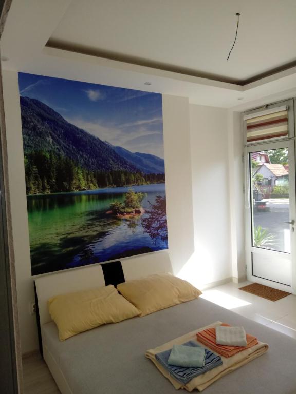1 dormitorio con una gran pintura en la pared en Dado, en Bijeljina