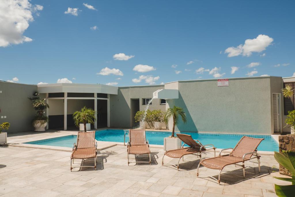 a patio with chairs and a swimming pool at Bristol Exceler Campo Grande in Campo Grande
