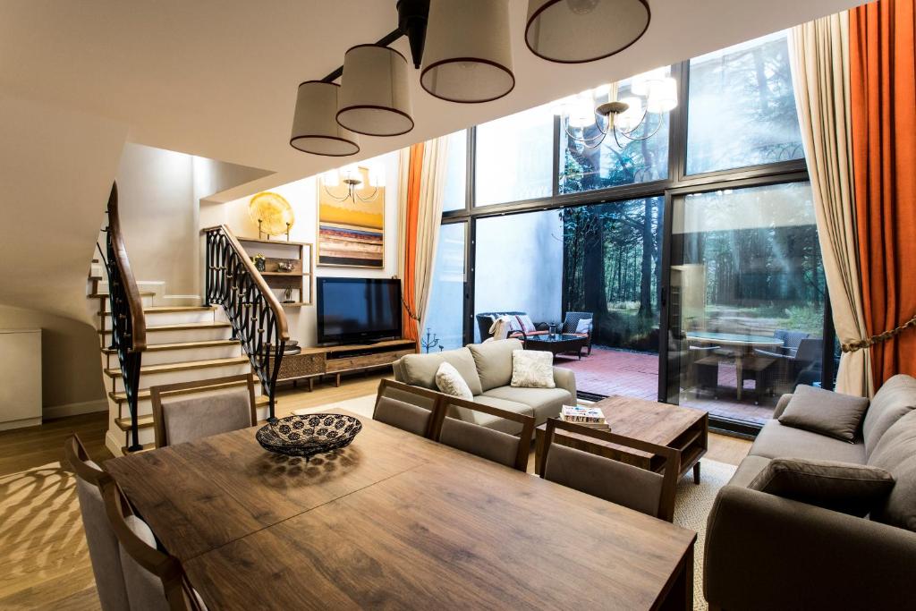 un soggiorno con tavolo, sedie e TV di Amazing Triplex Apartment By Deniz Suites a Istanbul