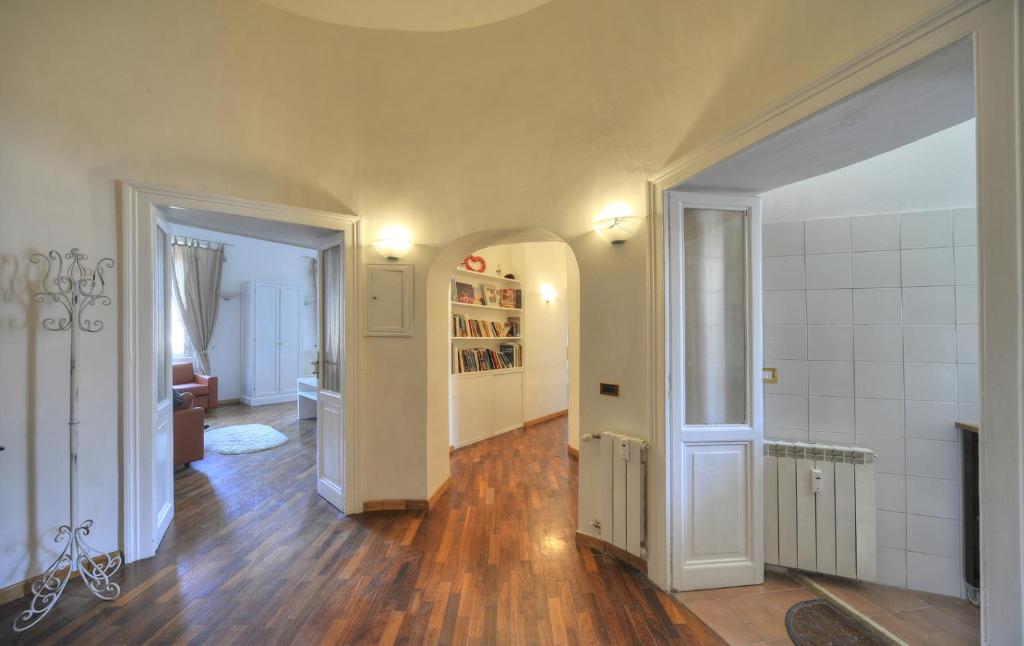 Cette chambre dispose d'un couloir avec du parquet et des murs blancs. dans l'établissement Rome Luxury House - The House, à Rome