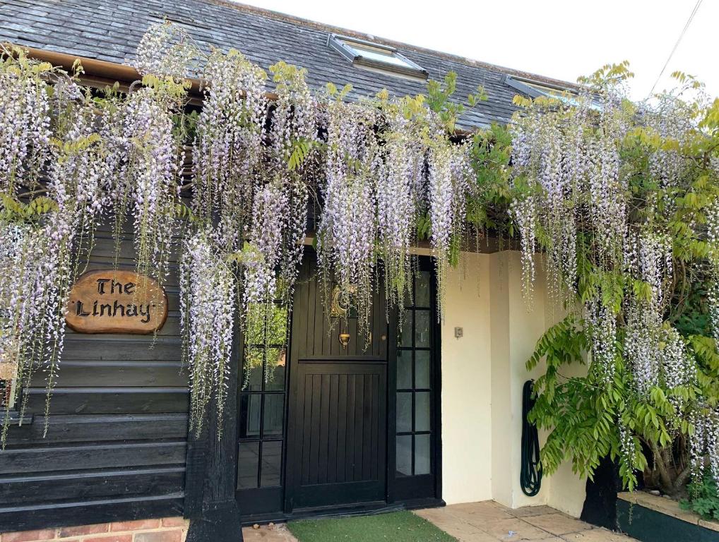 a house covered in wisteria in front of a door at Linhay -Farm Cottage in Sidmouth