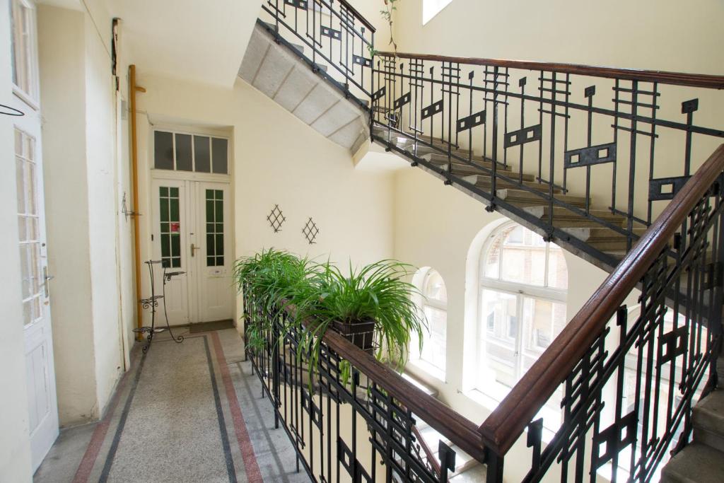 a hallway with stairs and plants in a building at Antikvilla Apartman in Szeged