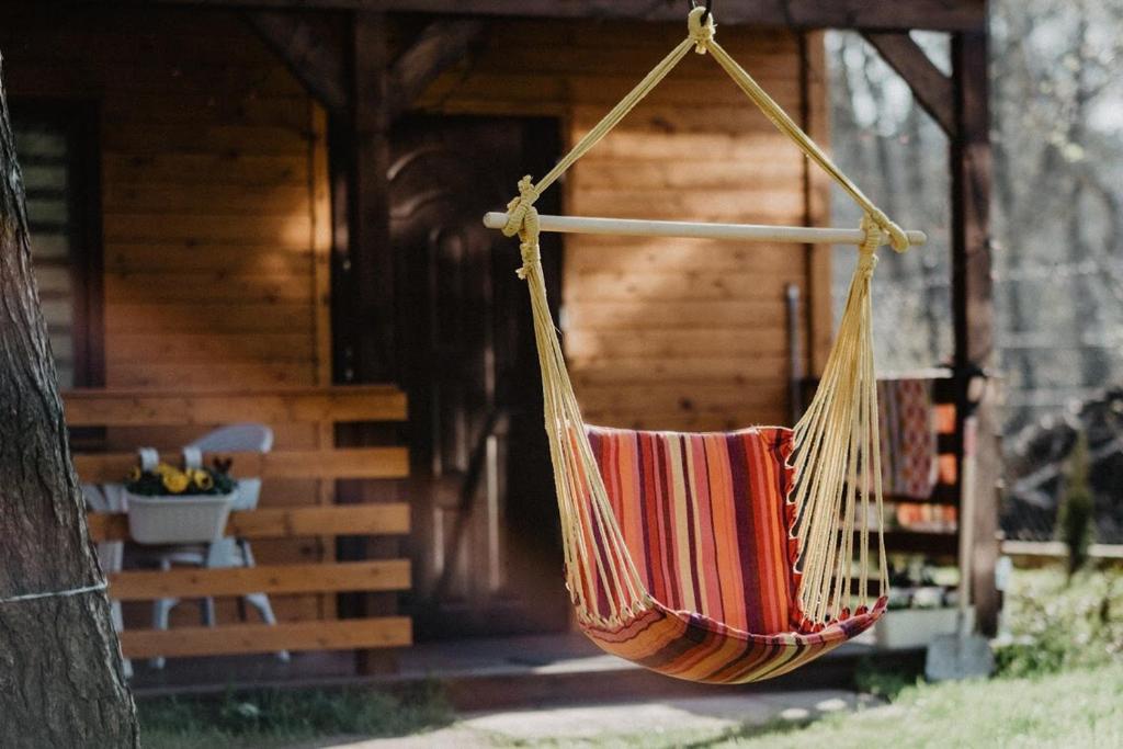 a hammock hanging in front of a cabin at Tumiło in Dziwnów
