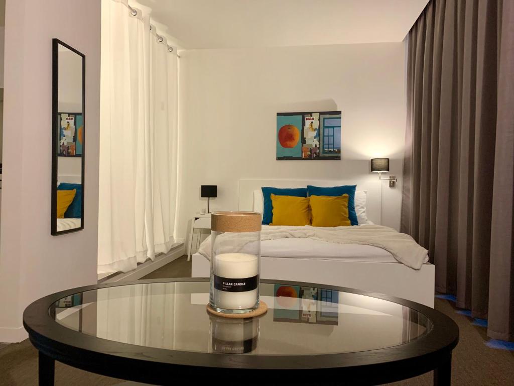 a living room with a bed and a glass table at Suite 336 in Menen
