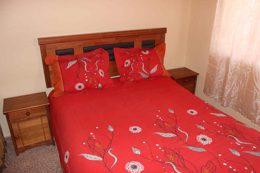 Un dormitorio con una cama roja con sábanas rojas y almohadas rojas. en casa saire en San Pedro de Atacama