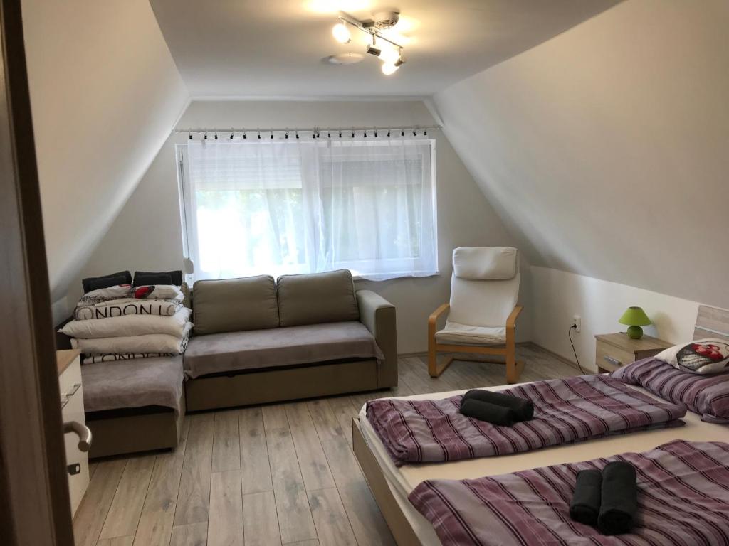 ein Wohnzimmer mit 2 Betten und einem Sofa in der Unterkunft Bendegúz Vendégház in Orfű