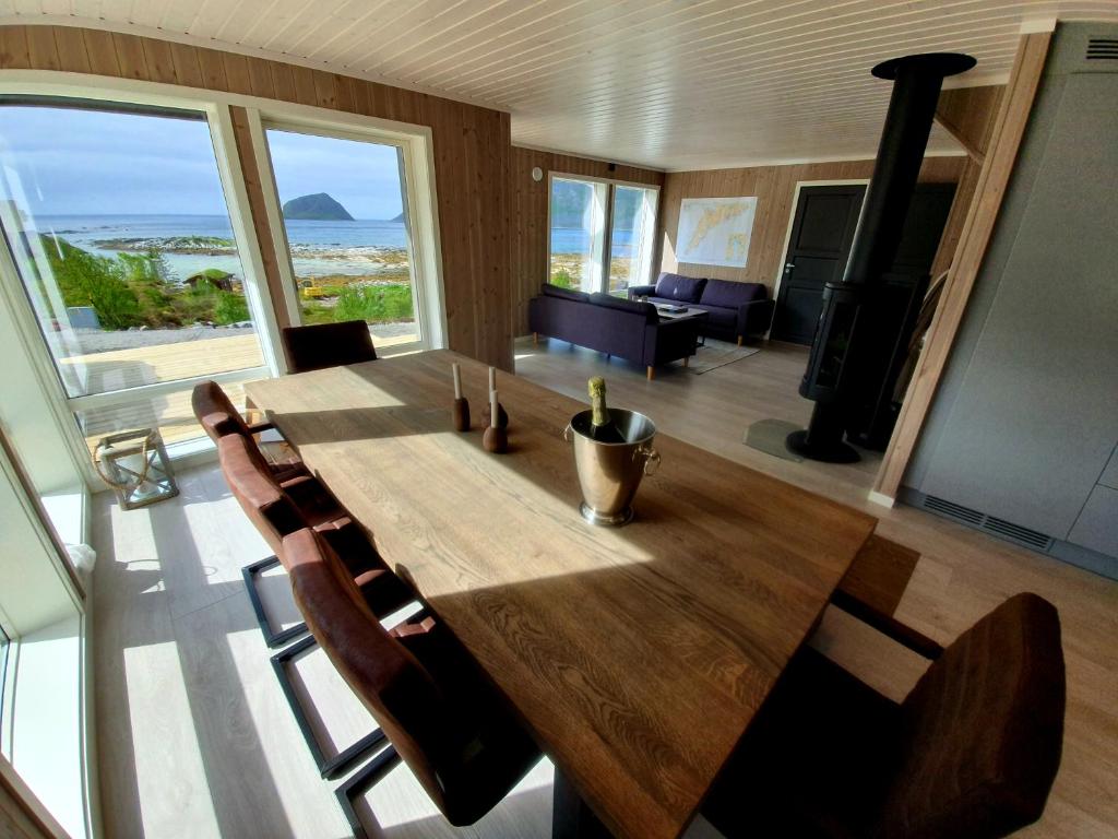 uma sala de jantar com uma grande mesa de madeira e cadeiras em Explorers Cabin Lofoten em Offersøya