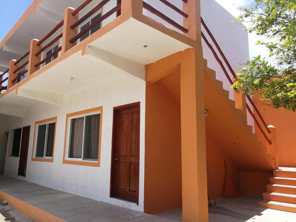una casa con paredes de color naranja y blanco y una escalera en Posada Antonia Bacalar, en Bacalar
