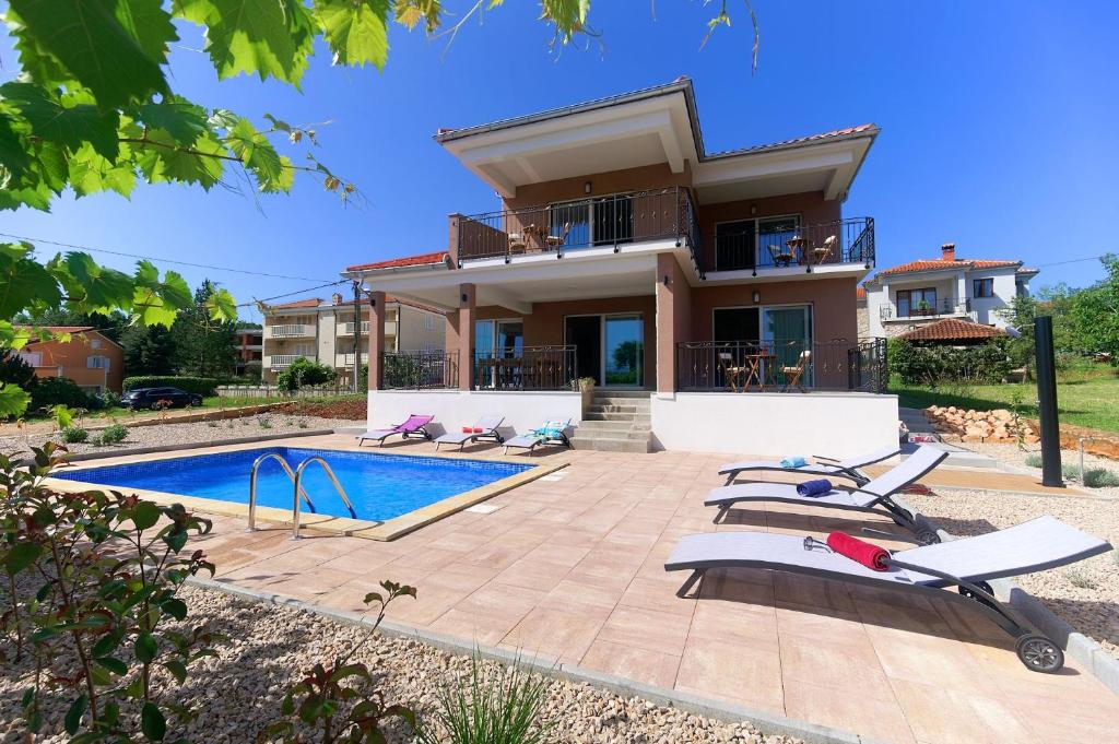 een villa met een zwembad en een huis bij Villa Nerium in Malinska