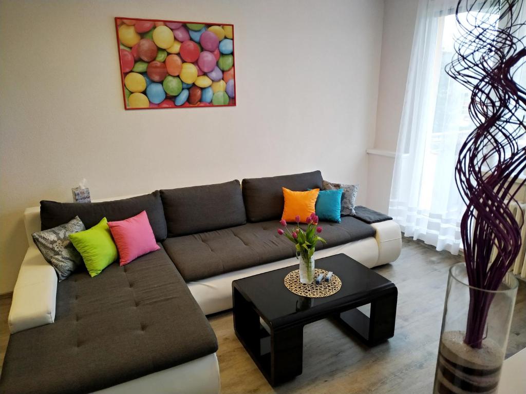 a living room with a brown couch with colorful pillows at Lentilka in Horní Planá