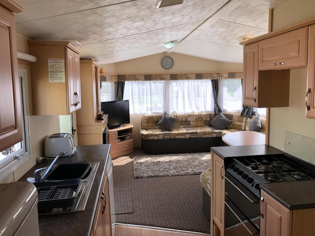 a kitchen and living room in an rv at 4 bedroom 10 berth caravans with Hot Tub ,Mountain Bikes Tattershall Lakes in Tattershall
