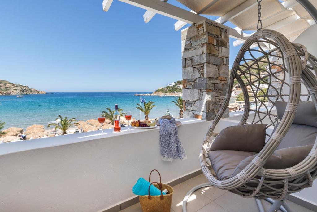 een kamer met een schommelstoel en uitzicht op de oceaan bij Blue Harmony Hotel in Kinion