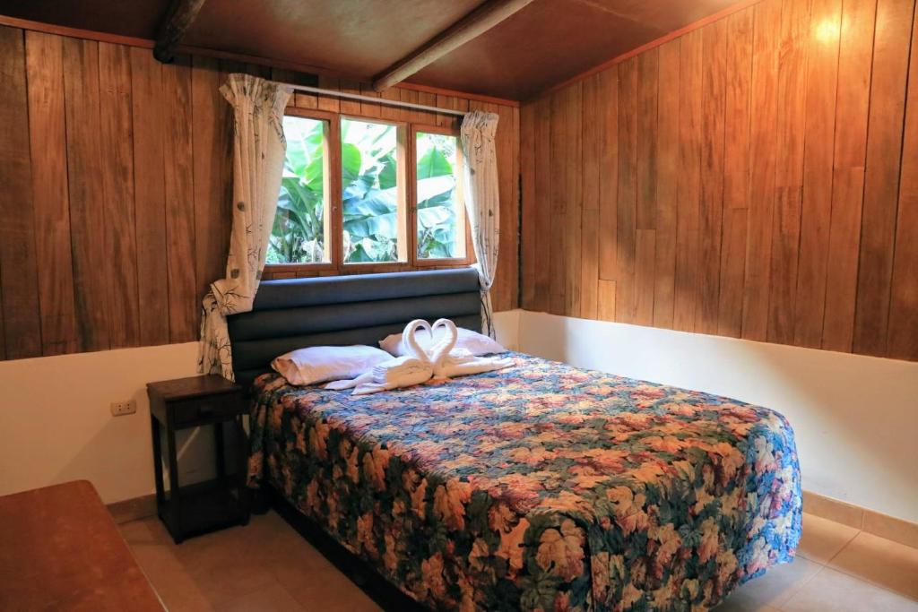 um quarto com uma cama com um laço em Mandor Machu Picchu em Machu Picchu