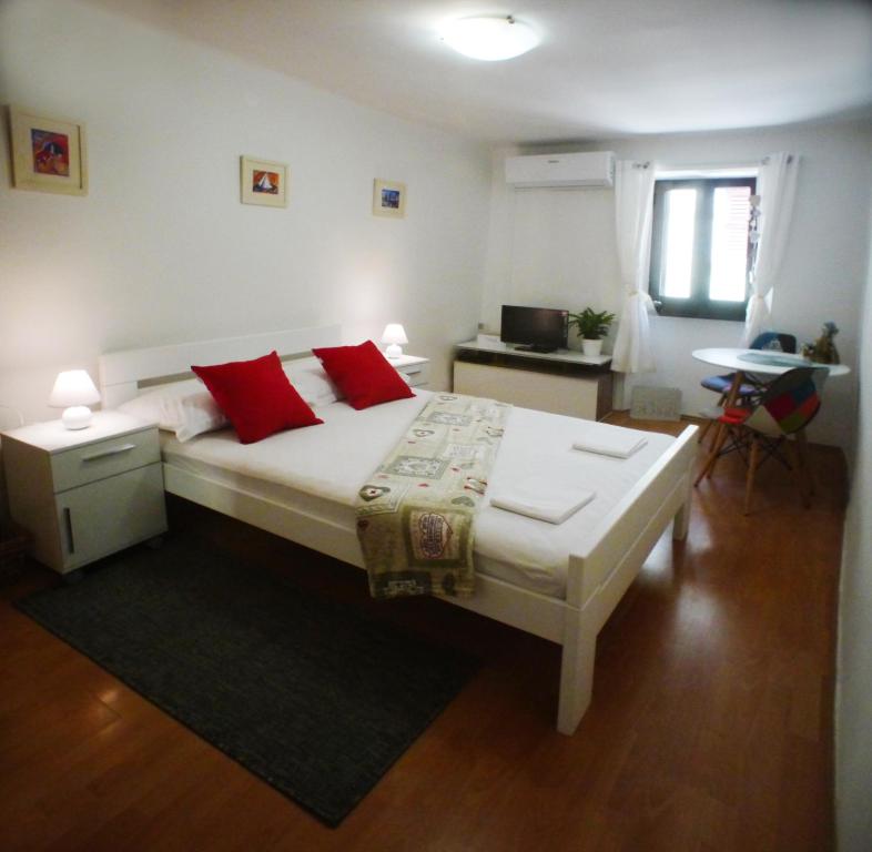 ein Schlafzimmer mit einem großen Bett mit roten Kissen in der Unterkunft Old City in Novigrad Istria