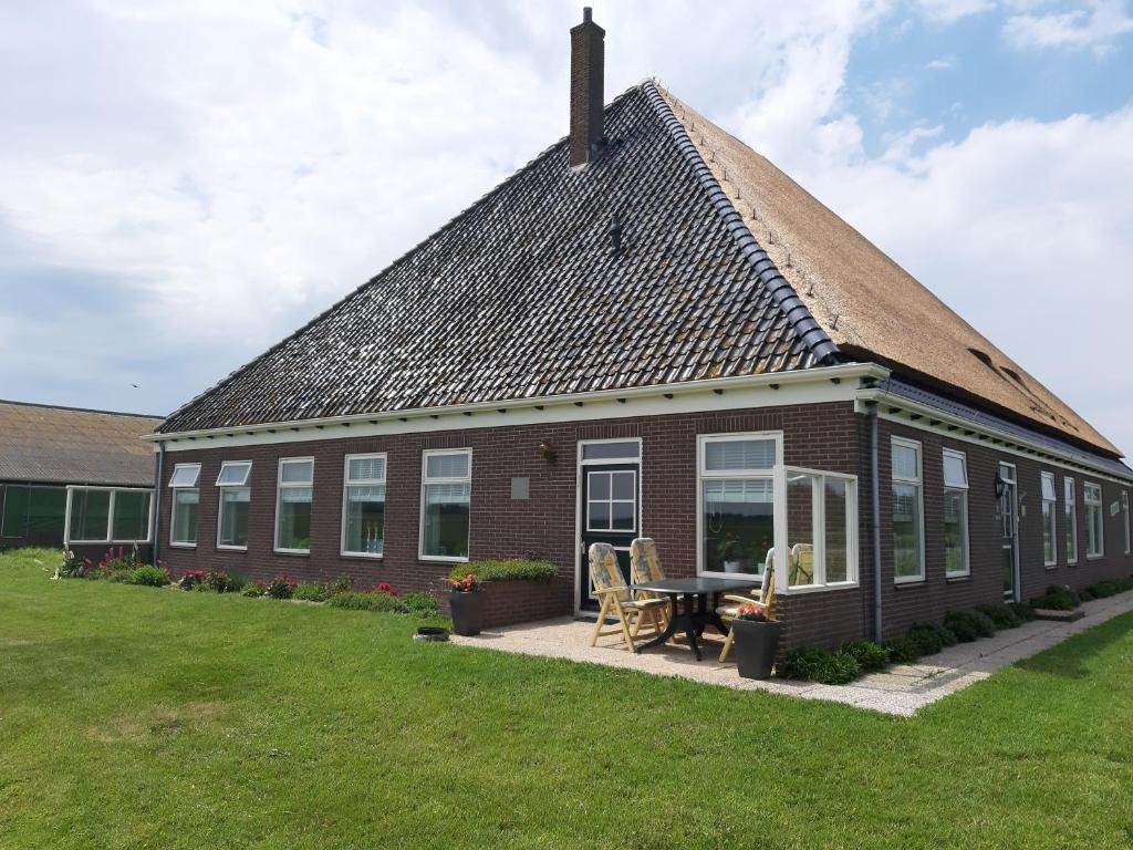a brick house with a table and chairs in a yard at Iefjeshoeve in Petten