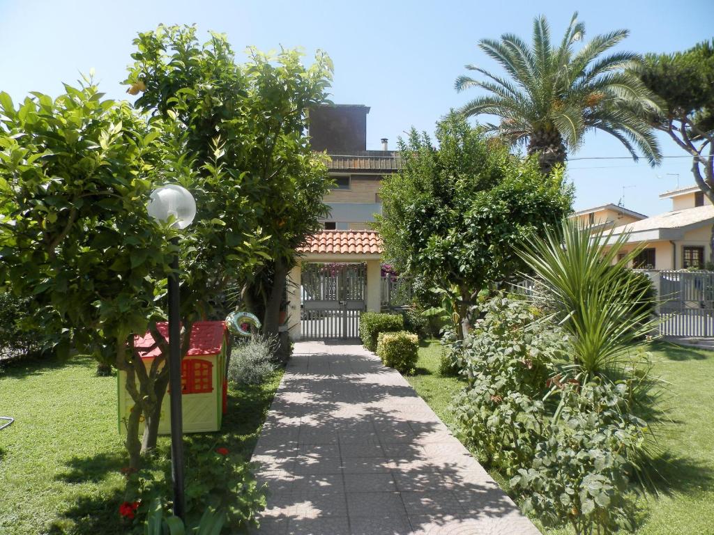 une passerelle devant une maison arborée dans l'établissement Luana Inn Holiday, à Fiumicino